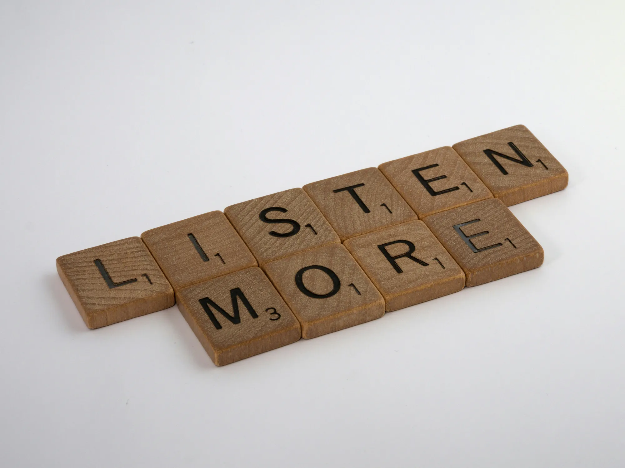 Scrabble Tiles spell out “Listen More”